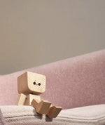 Verspielte Holzfigur mit sanfter Wippfunktion und wechselbaren Emotionen