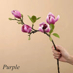 Atmosphärischer Kunstzweig mit realistischen Magnolienblüten